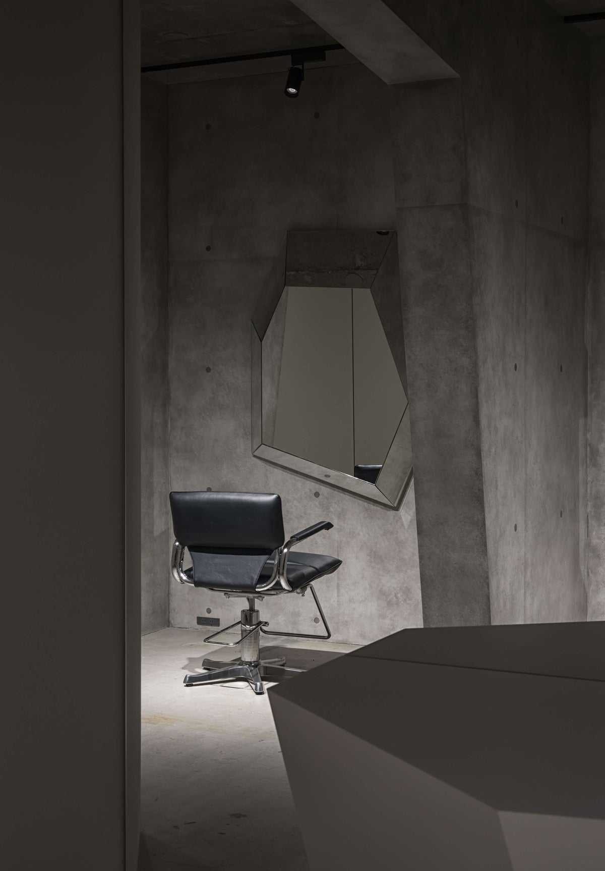 Takara Belmont Captain II styling chair at a mirror in a gray concrete salon