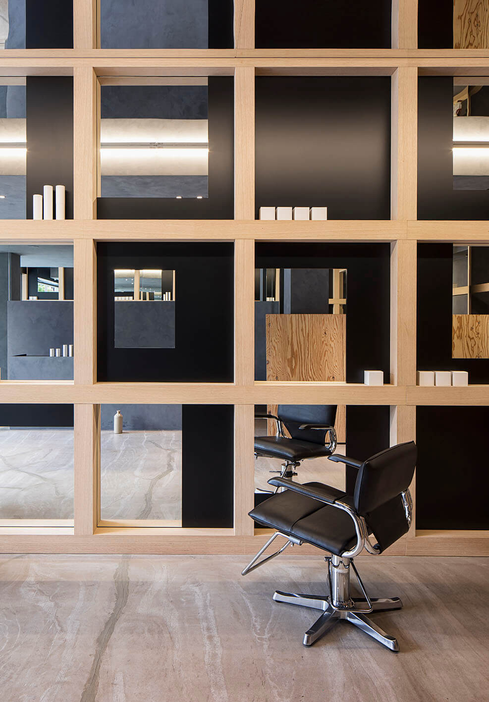 Takara Belmont Captain II styling chair beside a wood-framed salon mirror and shelves