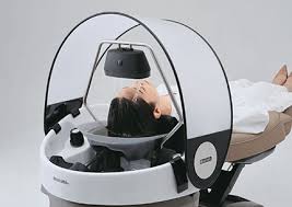 Open Takara Belmont YUME hood cover frame around a client at a shampoo bowl