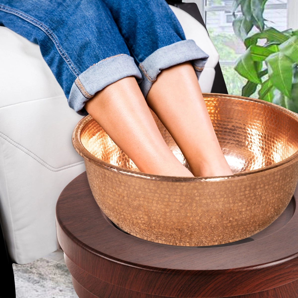 Client soaking feet in the copper bowl of a Living Earth Crafts rolling pedicure unit