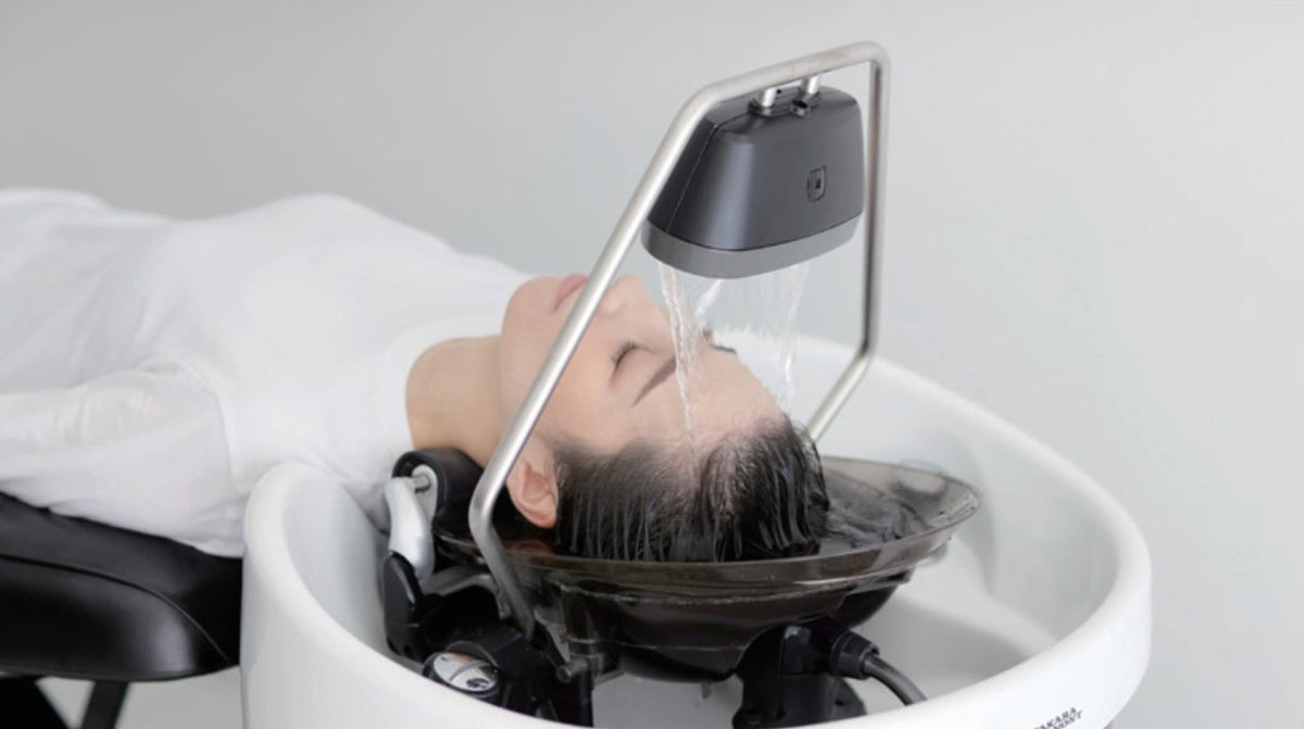 Client receiving a Takara Belmont YUME Head Bath treatment with water flowing over the scalp