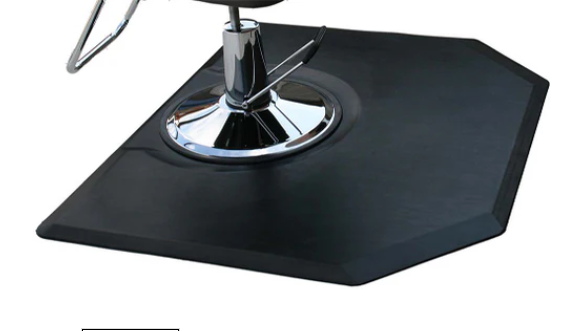 Black hexagonal salon and barber mat beneath a styling chair