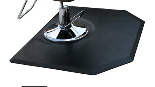 Black hexagonal salon and barber mat beneath a styling chair