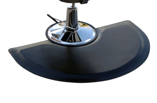 Black semicircular salon and barber mat beneath a styling chair