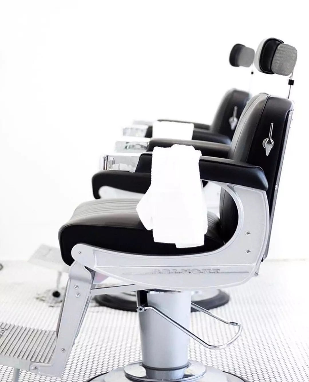 Side view of the 225 Classic Elegance barber chair with a towel hanging from the armrest