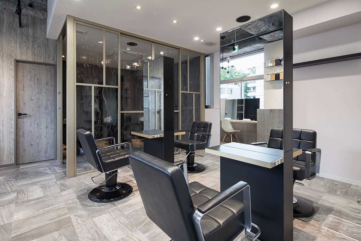 Black Takara Belmont Choco styling chairs at salon mirrors and concrete stations