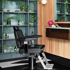 Black Takara Belmont Dainty barber chair with chrome footrest in a salon