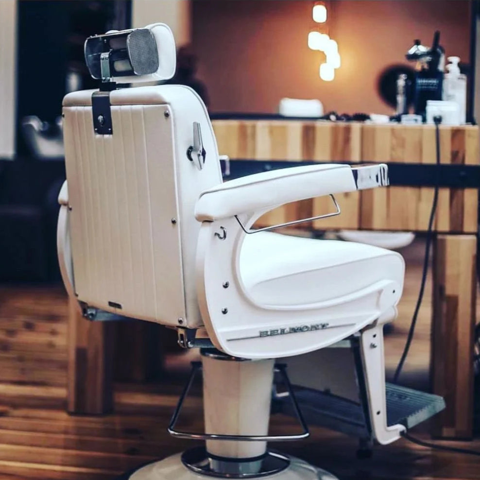 Rear and side view of the 225 Elite White Elegance barber chair in a barbershop