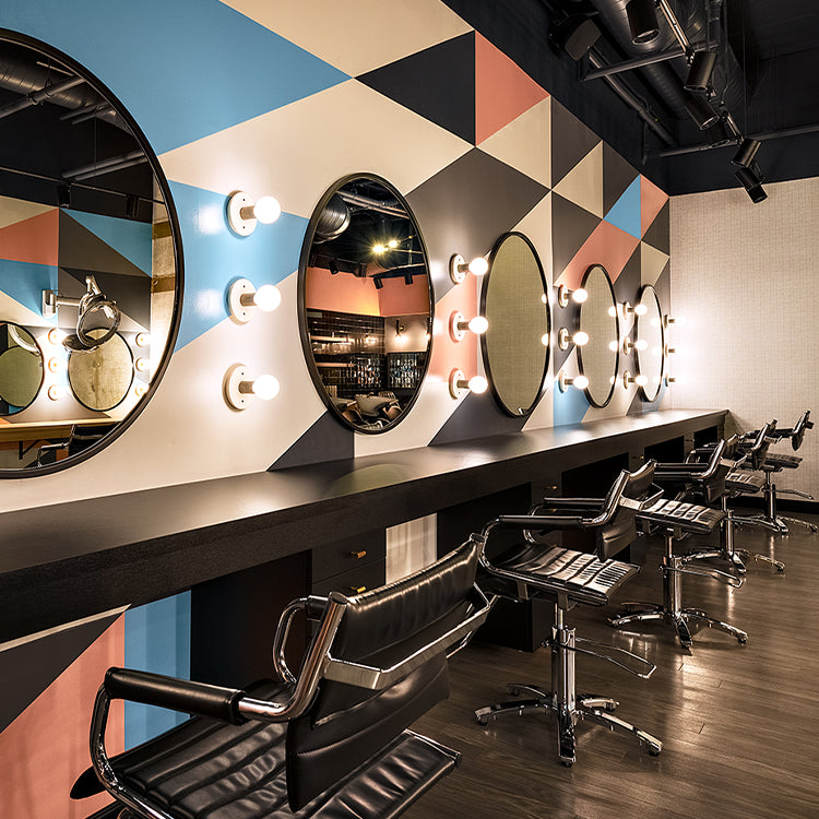 Takara Belmont Ghia styling chairs at circular mirrors in a salon with a geometric wall