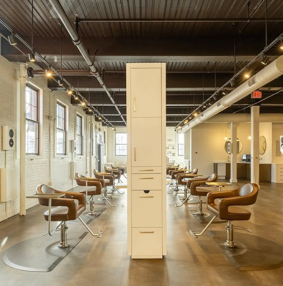 Takara Belmont Knoll styling chairs throughout a salon with exposed ceiling beams