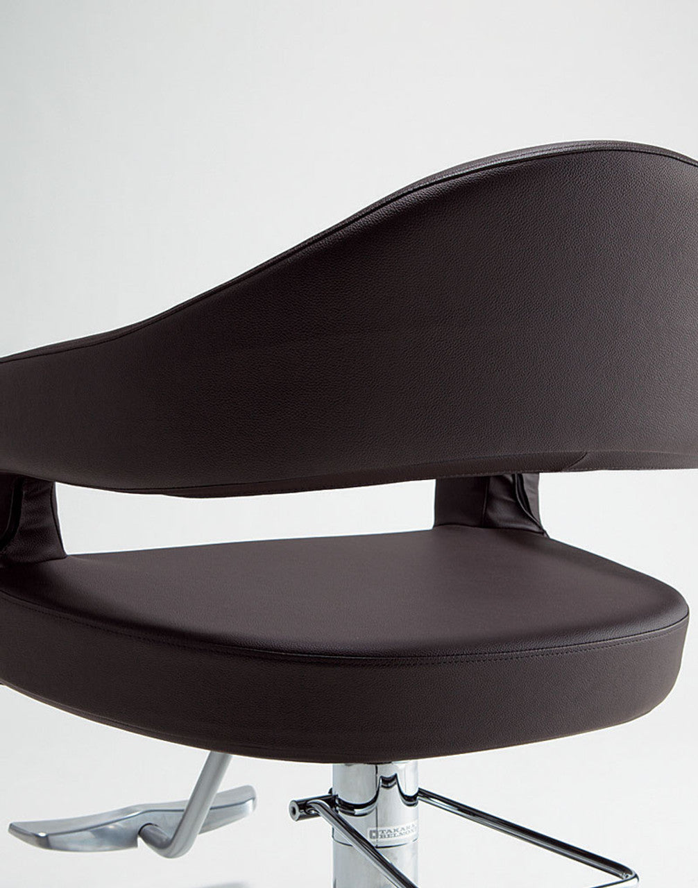Rear detail of the curved backrest and open design of a brown Takara Belmont Knoll styling chair