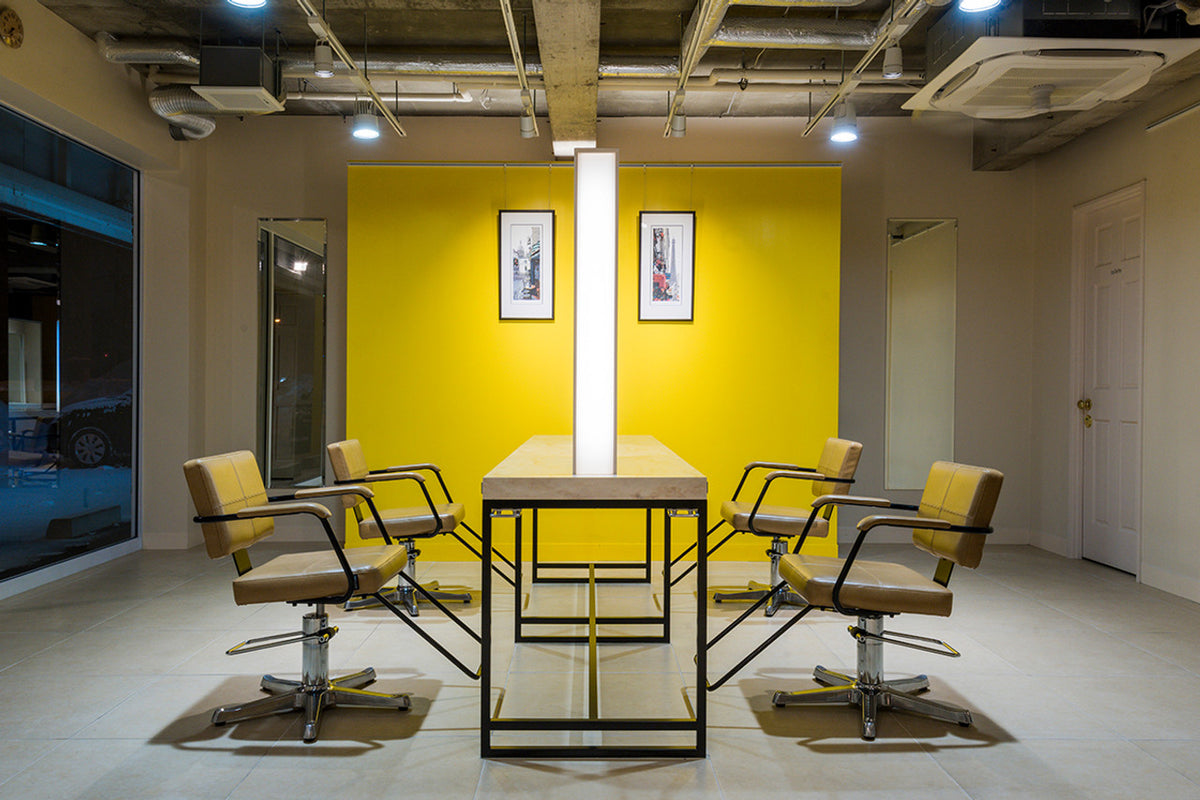Takara Belmont Shiki styling chairs around a salon workstation with a yellow accent wall