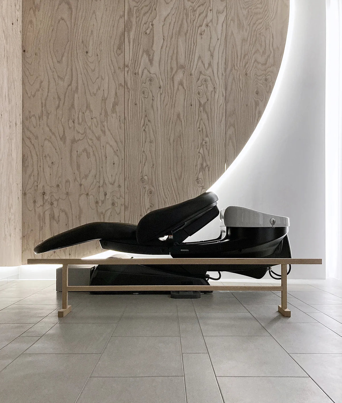 Side view of a black Takara Belmont YUME head spa shampoo unit reclined flat