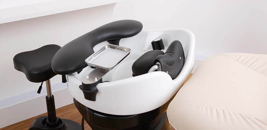 YUME lash device and pillow fitted to a shampoo bowl with a technician stool alongside