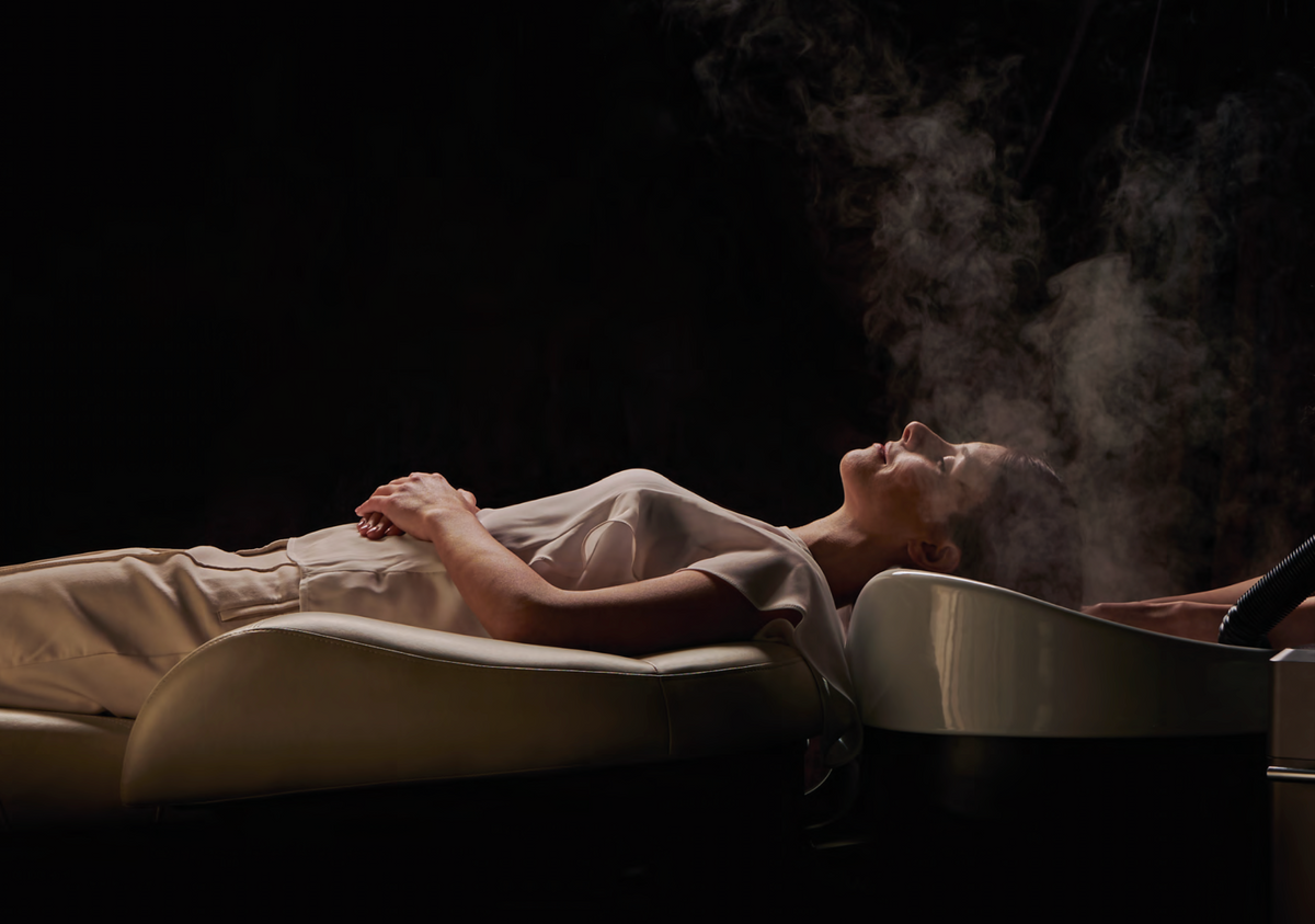 Client reclining on a Takara Belmont YUME unit during a mist head spa treatment