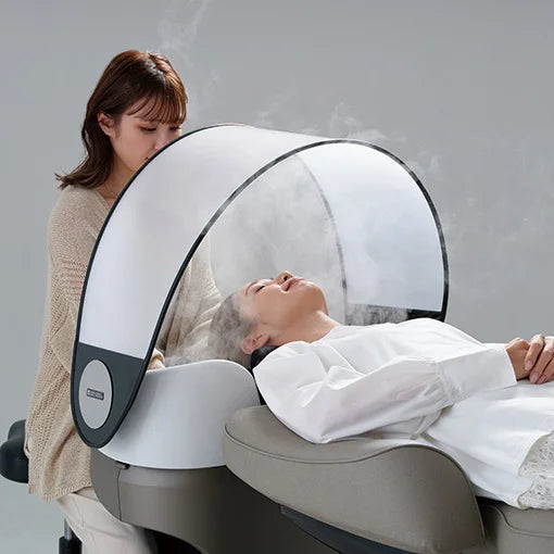 Client receiving a shampoo under the Takara Belmont YUME hood cover