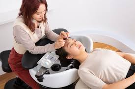Technician working at a YUME shampoo bowl fitted with the lash device and pillow