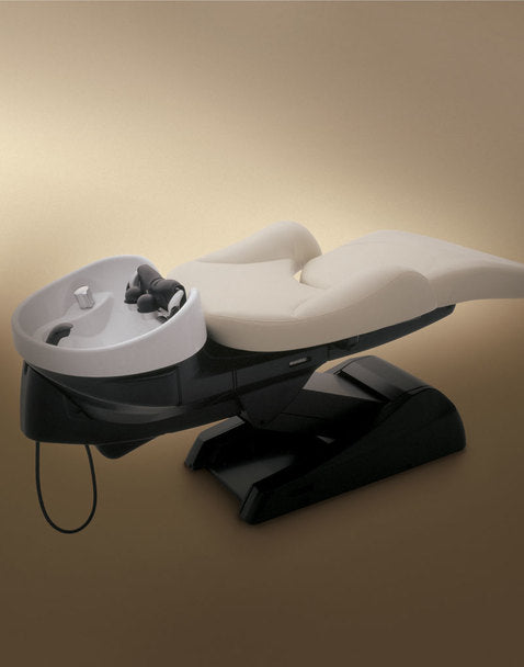 Takara Belmont YUME shampoo unit fully reclined with ivory upholstery and a white bowl